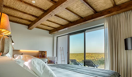 Retreat bedroom with beamed ceiling and sliding doors onto the Algarve hills