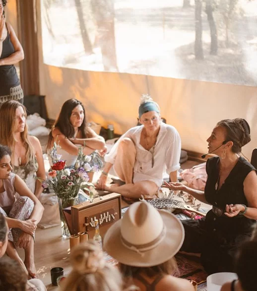 Beáta leading a shamanic circle with participants seated on the floor