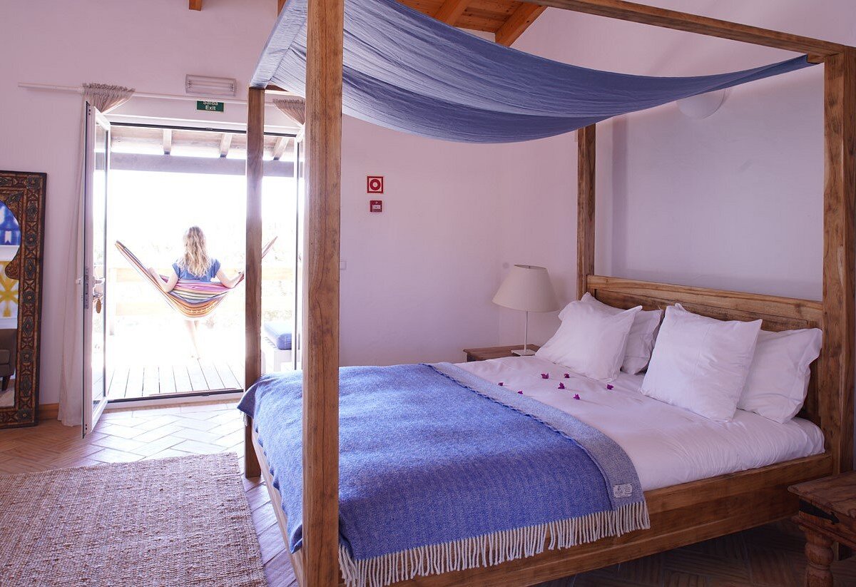 Four-poster bed suite opening onto a terrace with a hammock
